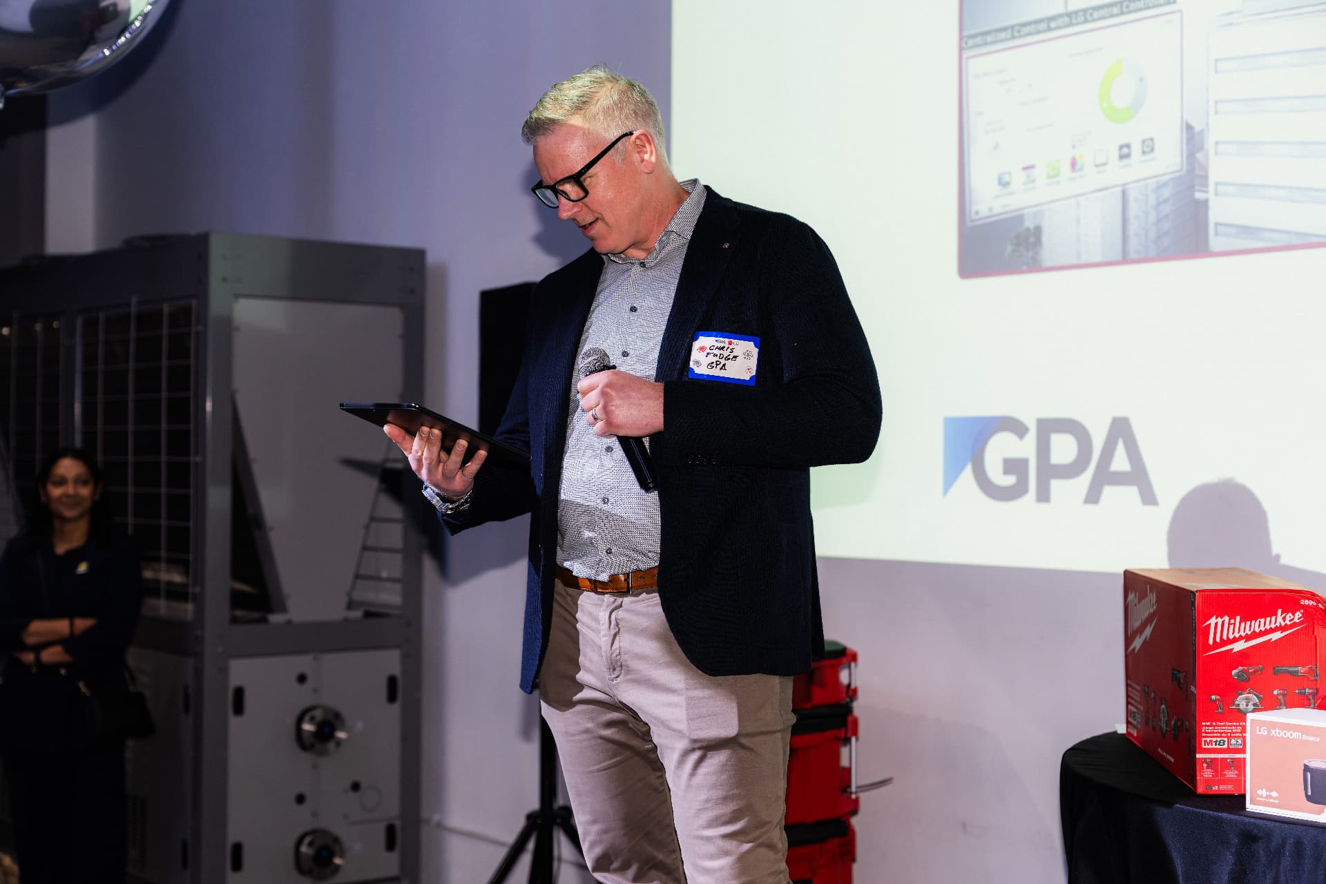 Host presenting on stage at a corporate event produced by ATM² Events